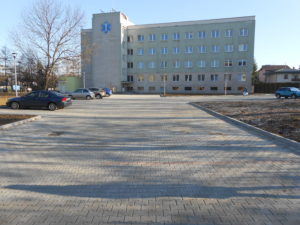 Duży plac przy budynku Szpitala na Placu Kuźnice 1 - wyłożone kostką miejsca parkingowe oraz drogi wewnętrze wokół budynku.